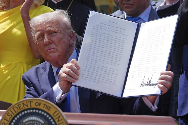 [워싱턴=AP/뉴시스] 도널드 트럼프 미국 대통령이 1일(현지 시간) 백악관 로즈가든에서 열린 국가 기도의 날 행사 중 종교 지도자들이 지켜보는 가운데 ‘종교 자유 위원회’ 설치 행정명령에 서명하고 있다. 트럼프 대통령은 대통령 직속으로 반기독교, 반유대주의적 편견과 폭력에 대응하는 종교 자유 위원회 설치 행정명령에 서명했다. 2025.05.02.