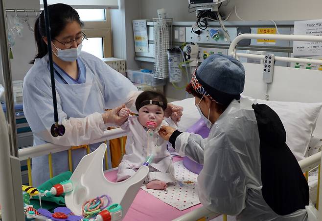 식도 폐쇄증, 심실중격 결손증, 소이증, 다지증 등 주요 장기 장애로 태어난 뒤부터 계속 중환자실에서 입원 치료를 받고 있는 소원이가 지난달 24일 오후 서울 서대문구 신촌 세브란스병원 심장혈관병원 소아심장중환자실에서 안영경 책임간호사와 한순희 공공후견인의 보살핌을 받고 있다. 김태형 기자 xogud555@hani.co.kr