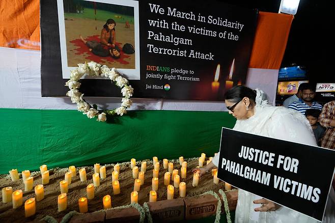 2025년 4월 25일 금요일, 인도 콜카타에서 파할감 인근 총기 난사 사건에 항의하는 시위 도중 한 여성이 희생자를 기리는 촛불을 어루만지고 있다. AP연합뉴스