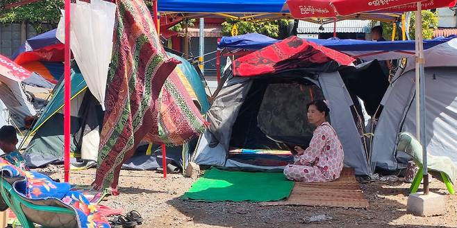 미얀마 만달레이의 임시 대피소. 한 여성이 텐트 밖 그늘에서 더위를 피하고 있다. 미얀마의 4월 평균 낮 기온은 40도였다.(사진 출처 : 미얀마 이라와디)