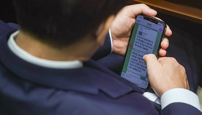 이재명 전 더불어민주당 대표가 지난 2022년 9월 1일 국회 본회의장에서 김현지 보좌관이 보낸 문자메시지를 확인하고 있다. 메시지에는 "백현동 허위사실공표, 대장동 개발관련 허위사실공표, 김문기 모른다 한거 관련 의원님 출석요구서가 방금 왔습니다. 전쟁입니다"라고 적혀있다.  /사진=한경DB