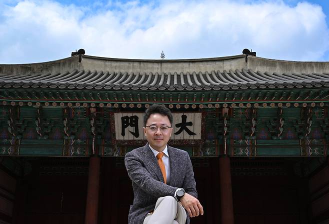Shin Chi-hoo, manager and research fellow at National Hanok Center, poses for a photo at the gate to Deoksugung in Seoul on April 21. (Im Se-jun/The Korea Herald)