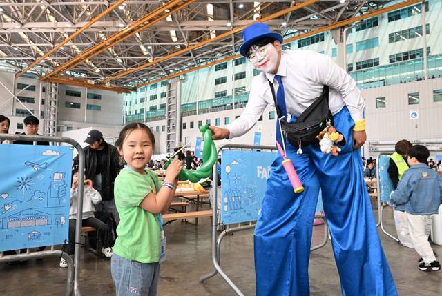 한 어린이가 행사에서 피에로가 만든 풍선을 선물로 받고 있다.