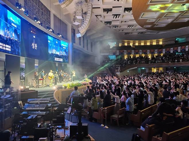 6일 서울 서초구 사랑의교회 본당에서 열린 크리스천 문화 페스티벌 ‘레디컬’에 참가한 1만여 명의 청년들이 성찬식을 진행하고 있다.