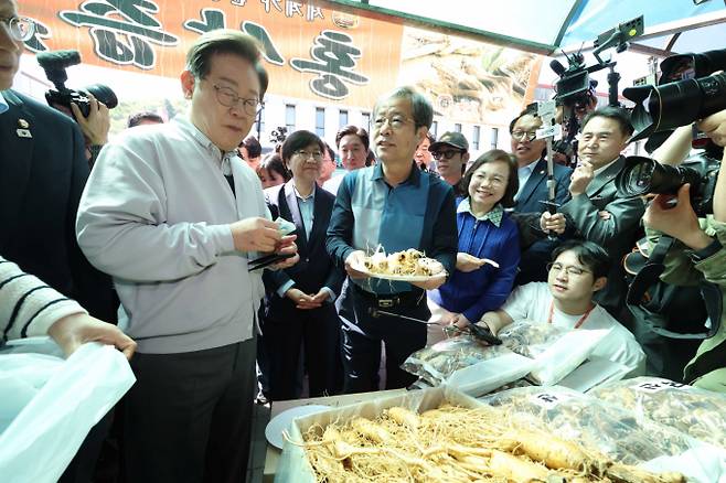 이 후보는 곧이어 전북 진안 새참거리로 이동해 지역화폐를 통한 기본소득 구상을 구체적으로 설명했. 사진은 이재명 더불어민주당 대선후보가 7일 전북 진안군 새참거리 인근에서 수삼을 맛보며 상인과 대화를 하는 모습. /사진=뉴시스