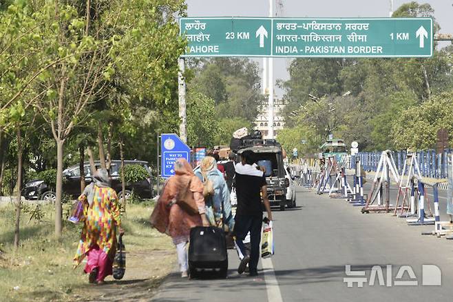 [암리차르(인도)=AP/뉴시스]인도를 방문했던 파키스탄 국민들이 4월 25일 암리차르의 와가 국경검문소를 통해 파키스탄으로 귀국하려고 고속도로를 따라 걷고 있다. 히말라야 지역 카슈미르의 고도로 군사화된 국경에서는 인도군과 파키스탄군 사이에 잠시 총격전이 벌어졌다. 양국이 영유권 분쟁을 하는 카슈미르 지역에서는 지난 달 관광객들 피습사건 이후 미사일 공격등 사태가 악화하고 있다.  2025.05.07.