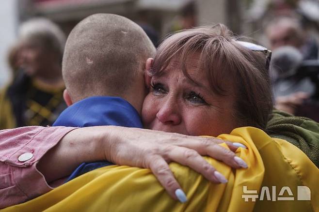 [우크라이나=AP/뉴시스] 6일(현지 시간) 러시아와의 포로 교환을 통해 석방된 우크라이나 군인이 장소가 알려지지 않은 곳에 도착해 가족과 재회하고 있다. 양국은 이날 205명의 포로를 교환했다. 2025.05.07.