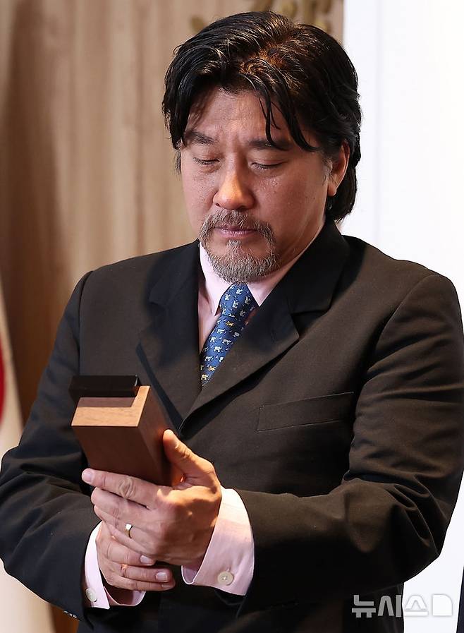 [서울=뉴시스] 정병혁 기자 = 서울시 홍보대사로 위촉된 에드워드 리 셰프가 7일 서울 중구 서울시청 집무실에서 열린 위촉식에서 위촉패를 바라보고 있다. (공동취재) 2025.05.07. photo@newsis.com