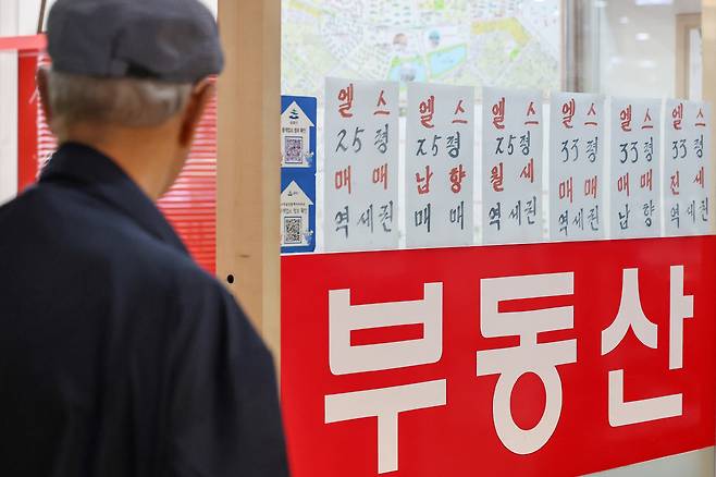 한 시민이 부동산 중개업소 매물 정보를 들여다보고 있다.&nbsp;경기도 아파트 거래량이 7개월 만에 1만 건을 넘어서는 등 매수세가 다시 살아나고 있다. 특히 9억 원 초과 아파트 거래 비중이 역대 최고치를 기록하며, 고가 아파트 수요 회복 조짐도 나타나고 있다. 뉴스1