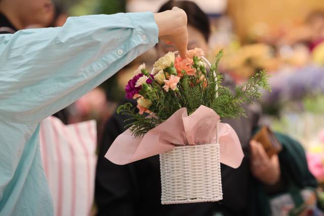 어버이날을 앞둔 6일 서울 서초구 양재꽃시장을 찾은 시민이 카네이션을 살펴보고 있다. 연합뉴스