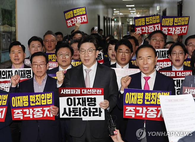 법사위 전체회의장 앞 구호 외치는 국민의힘 (서울=연합뉴스) 박동주 기자 = 7일 서울 여의도 국회 법제사법위원회 전체회의장 앞에서 국민의힘 의원들이 '이재명 면죄입법 즉각중지' 등의 내용이 적힌 손팻말을 들고 구호를 외치고 있다. 
    국회 법제사법위원회는 이날 법안심사소위원회를 열어 대통령 당선 시 진행 중인 형사재판을 정지하도록 하는 내용의 형사소송법 개정안을 의결했다. 2025.5.7 pdj6635@yna.co.kr