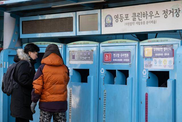 지난해 1월 서울 영등포구의 클린하우스(폐품 배출장)에서 어르신이 쓰레기를 버리러 온 주민의 분리배출을 돕고 있다. 한국일보 자료사진