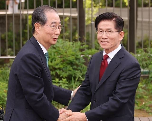 김문수 국민의힘 대선 후보(오른쪽)와 한덕수 무소속 대선 예비후보가 8일 오후 국회 사랑재에 위치한 커피숍에서 만나 악수하고 있다. 연합뉴스