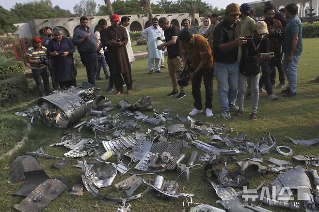 [바하왈푸르=AP/뉴시스] 사진은 파키스탄 기자들이 7일 펀자브주 바하왈푸르 인근, 인도의 미사일 공격으로 파손된 사원 건물 부지에서 미사일 파편을 촬영하고 있는 모습. 2025.05.08.