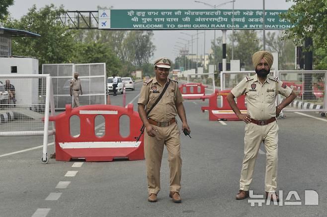 [암리차르(인도)=AP/뉴시스]인도 경찰들이 7일 폐쇄된 암리차르 공항으로 가는 도로를 막고 교통을 통제하고 있다. 인도 항공사들이 8일 파키스탄과의 긴장이 고조된 가운데 북부와 서부 지역 24개 이상의 공항에서 운항을 중단했다. 2025.05.08.