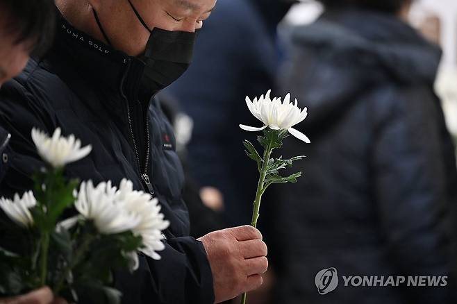 희생자에 헌화하는 제주항공 참사 유가족 (무안=연합뉴스) 정다움 기자 = 제주항공 여객기 참사 49일째인 15일 오전 전남 무안국제공항 분향소에서 열린 49재 합동위령제에서 유족들이 헌화하고 있다. 2025.2.15 [공동취재] daum@yna.co.kr