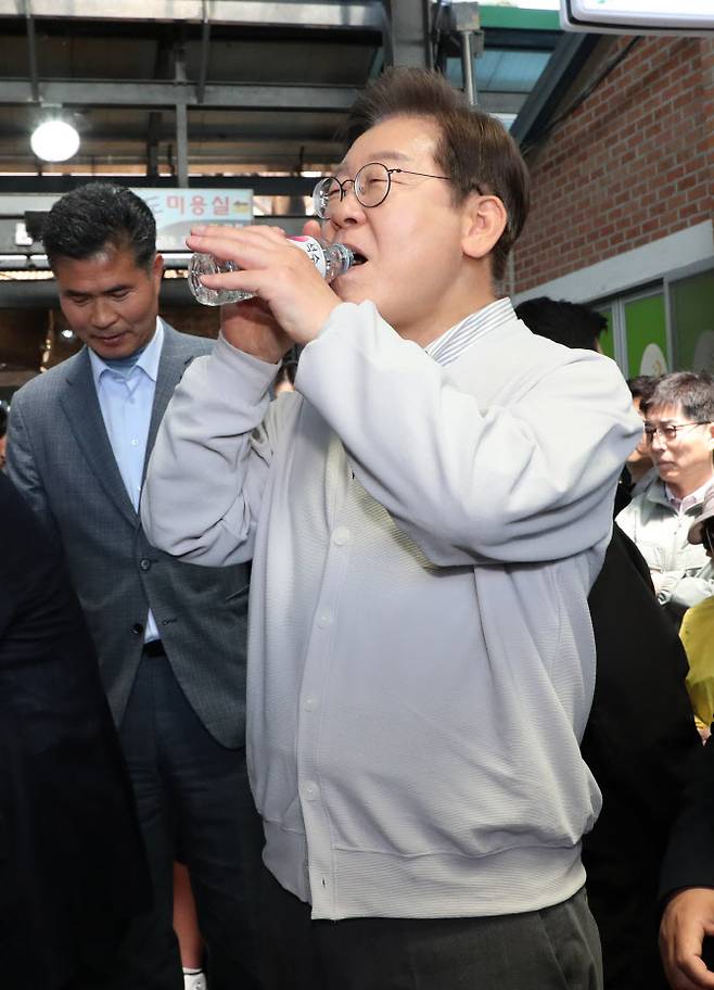 Lee Jae-myung, presidential candidate of the Democratic Party of Korea, pauses to drink water while greeting citizens at Imsil Market in Imsil County, North Jeolla Province, during his “Neighborhood Listening Tour: Cross-Country Edition” on May 7. (Photo = Yonhap News)