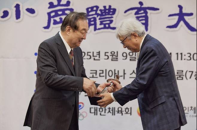 정대철 소강민관식육영재단 이사장으로부터 대상트로피를 받고 있는 이인정 회장, 사진=(주)태인