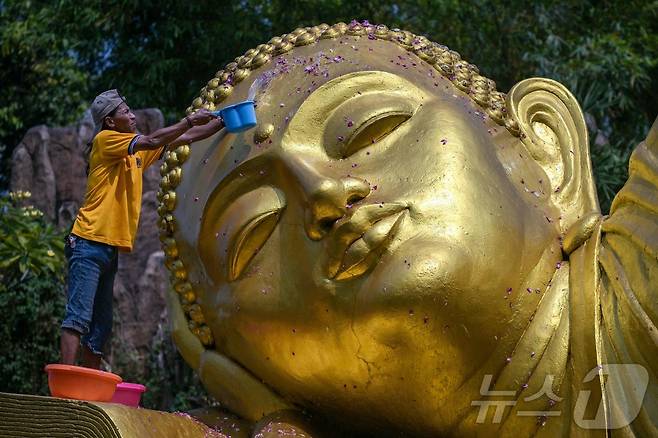 베삭 축제를 앞둔 7일(현지시간) 인도네시아 모조케르토의 마하 비하라 모조파히트 사원에서 인부들이 불상을 청소하고 있다. ⓒ AFP=뉴스1