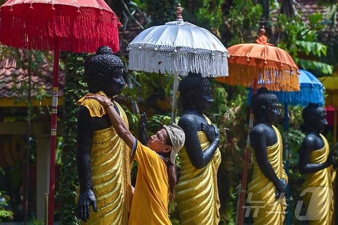 베삭 축제를 앞둔 7일(현지시간) 인도네시아 모조케르토의 마하 비하라 모조파히트 사원에서 인부들이 불상을 청소하고 있다.ⓒ AFP=뉴스1