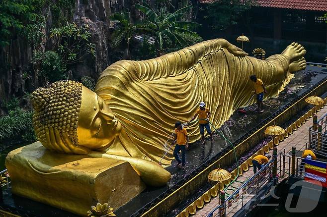 베삭 축제를 앞둔 7일(현지시간) 인도네시아 모조케르토 마하 비하라 모조파히트의 사원에서 인부들이 불상을 청소하고 있다. ⓒ AFP=뉴스1