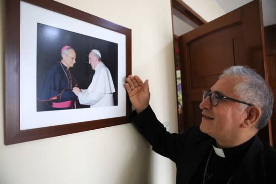 페루 카야오에서 루이스 알베르토 바레라 교구장이 5월 8일 페루 카야오 교구에서 프란치스코 전 교황과 신임 프레보스트 교황이 함께 있는 사진을 보여주고 있다. 새 교황은 페루에서 20년 이상 헌신했고 페루 국적도 취득했다. AFP=연합뉴스