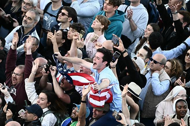 8일(현지시간) 바티칸 성 베드로 광장에서 새 교황인 레오 14세 선출 소식이 전해지자 한 남성이 미국 국기를 들고 환호하고 있다. AFP연합뉴스