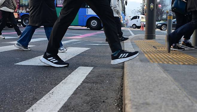 People in Seoul cross the street during morning commute hours on April 7. (Lee Sang-sub/The Korea Herald)