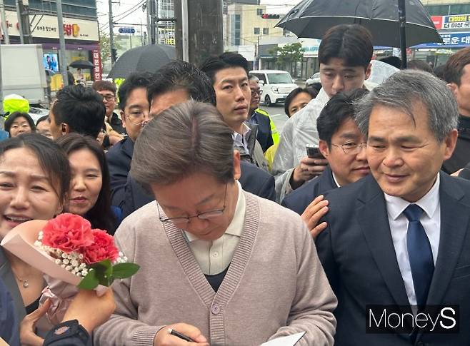 칠곡군 석적읍도 보수 성향이 강한 지역이지만 많은 시민들이 우비를 입고 이 후보의 도착을 기다렸다. 사진은 이 후보가 한 지지자에게 사인해주는 모습. /사진=김성아 기자