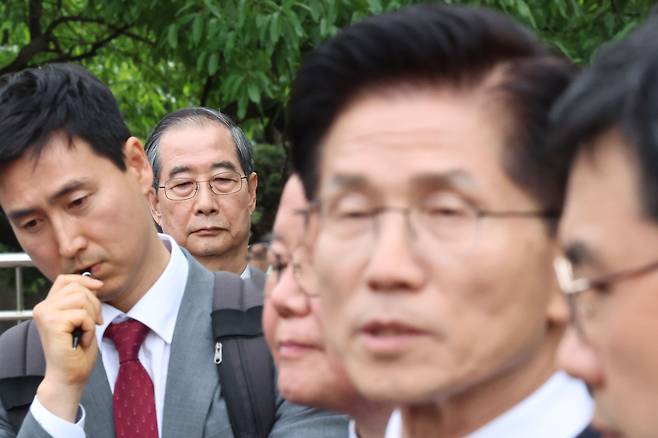 한덕수 무소속 대선 예비후보가 8일 서울 국회 사랑재에 위치한 커피숍에서 회동을 마친 후 김문수 후보의 백프리핑을 듣고 있다. 2025.5.8 [공동취재] <연합뉴스>