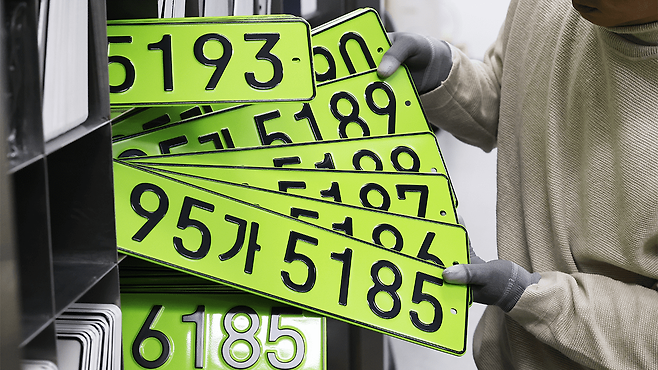 연두색 번호판을 정리하는 작업자. YTN캡처