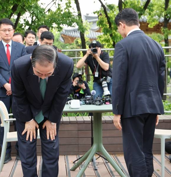 한덕수(왼쪽) 전 국무총리와 김문수 국민의힘 대선 후보가 8일 국회 카페 강변서재에서 회동을 마친 뒤 자리에서 일어나 인사하고 있다. 한 전 총리는 취재진에게 허리 굽혀 인사하는 모습. 홍윤기 기자
