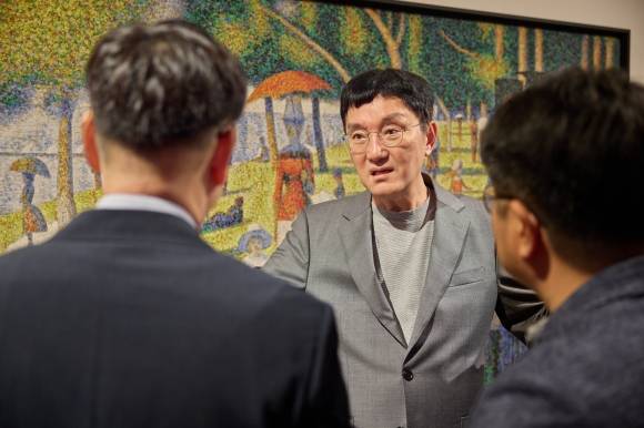 조세현 중구문화재단 사장이 지난달 21일 충무아트센터 갤러리에서 열린 ‘더 글로리어스 월드’ 전시 관련 기자간담회에서 관계자들과 작품에 대한 얘기를 나누고 있다.﻿ 중구문화재단 제공