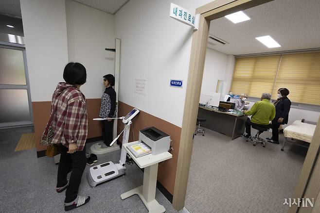 임경수 고부보건지소장이 진료 중인 가운데 보건소를 찾은 주민들이 키를 재고 있다. ⓒ시사IN 이명익