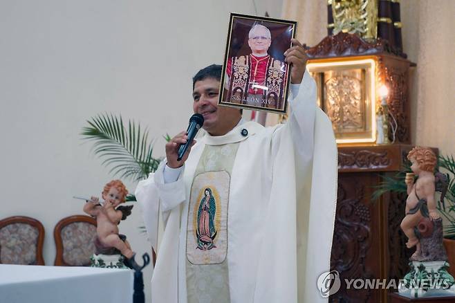 레오14세 교황 선출 기뻐하는 아우구스티노 수도회 사제 아우구스티노회 북부 수석대리인 라미로 카스티요 신부가 레오14세 교황의 사진을 들고 기뻐하고 있다. [AFP=연합뉴스 자료사진. 재판매 및 DB 금지]