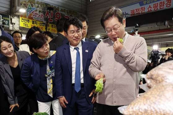 이재명 더불어민주당 대선후보가 9일 경북 지역에서 ‘경청 투어’를 진행했다. 이날 이 후보가 영천시 공설시장에서 채소를 맛보고 있다. [뉴시스]