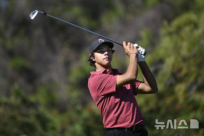 [올랜도=AP/뉴시스] 타이거 우즈의 아들 찰리가 22일(현지시각) 미 플로리다주 올랜도의 리츠 칼턴 골프클럽에서 열린 PNC 챔피언십 최종 2라운드 4번 홀에서 홀인원을 기록하는 타구를 지켜보고 있다. 우즈 부자는 최종 합계 28언더파 116타로 베른하르트 랑거(독일) 부자와 동타를 이뤄 연장 끝에 준우승을 차지했다. 2024.12.23.