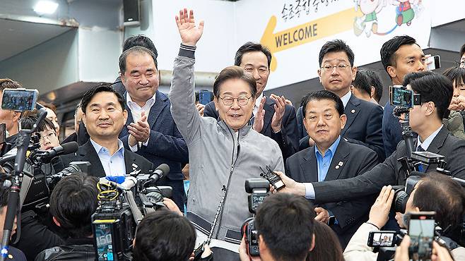 더불어민주당 이재명 대선 후보가 속초관광수산시장에서 시민들을 향해 손을 들어보이고 있다. 뉴스1