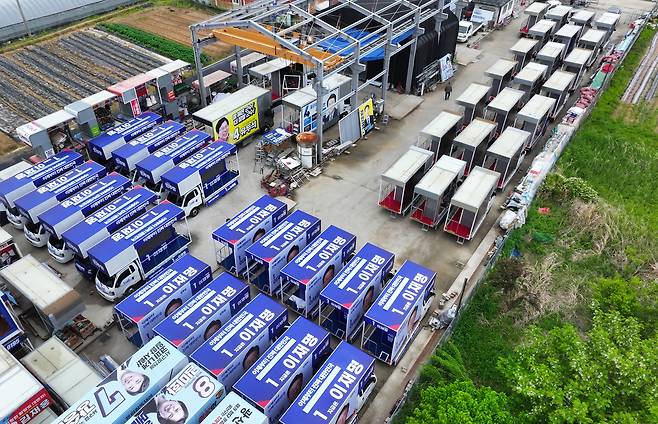 제21대 대통령 선거 후보 등록 마감일인 11일 광주 광산구에 위치한 차량광고업체 한양E&C에 선거 유세에 투입될 차량이 놓여 있다. 더불어민주당 유세 차량(왼쪽)과 국민의힘 유세 차량의 모습 [연합]