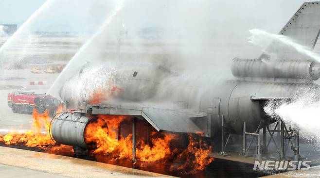 [인천공항=뉴시스] 김선웅 기자 = 5일 인천국제공항 활주로에서 착륙 시도 항공기와 원격주기장 이동 차량 추돌로 인한 화재·폭발을 가정해 열린 2024 READY Korea 2차 훈련에서 소방 당국이 화재를 진압하고 있다. (공동취재) 2024.06.05. photo@newsis.com