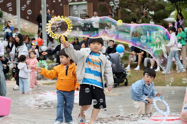 [임실=뉴시스] 김종효 기자 = 임실치즈테마파크의 어린이날 행사에 참여한 어린이들이 도구를 이용해 긴 거품방울을 만들어 내고 있다. (사진=임실군 제공) 2025.05.05. photo@newsis.com  *재판매 및 DB 금지
