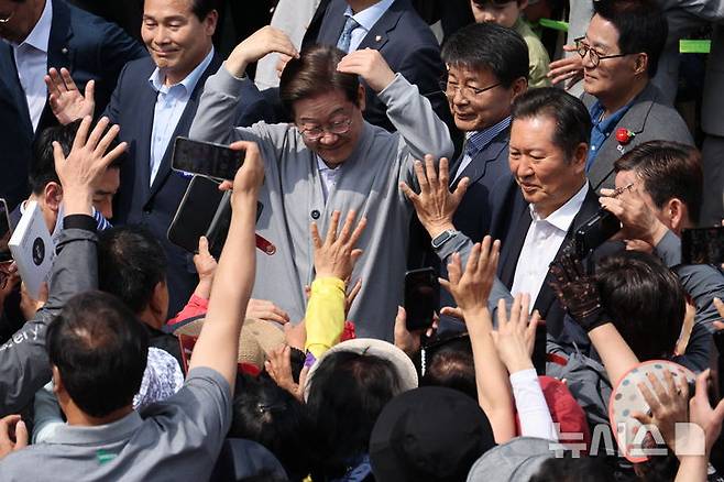 [영암=뉴시스] 조성우 기자 = 민심을 청취하는 '경청 투어'에 나선 이재명 더불어민주당 대선후보가 11일 전남 영암군 독천터미널 인근에서 군민들과 인사를 나누고 있다. 2025.05.11. xconfind@newsis.com