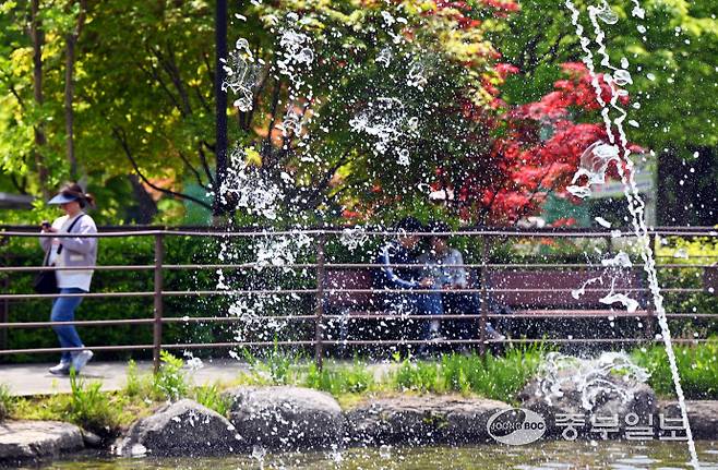 초여름 날씨를 보인 12일 오후 안산시 노적봉폭포공원을 찾은 시민들이 시원하게 쏟아지는 폭포수를 바라보고 있다. 김경민기자