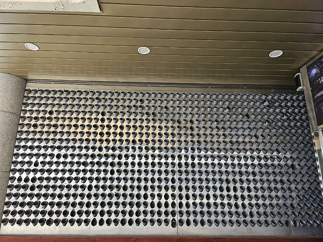 광주 동구가 미세먼지 휴식공간의 일환으로 구청사 입구에 조성한 ‘식물벽’이 관리 부실로 말라비틀어져 있다(사진 上). 동구는 12일 화분 교체를 위해 식물벽에 꽂힌 864개 화분 모두를 제거했다./안재영 기자