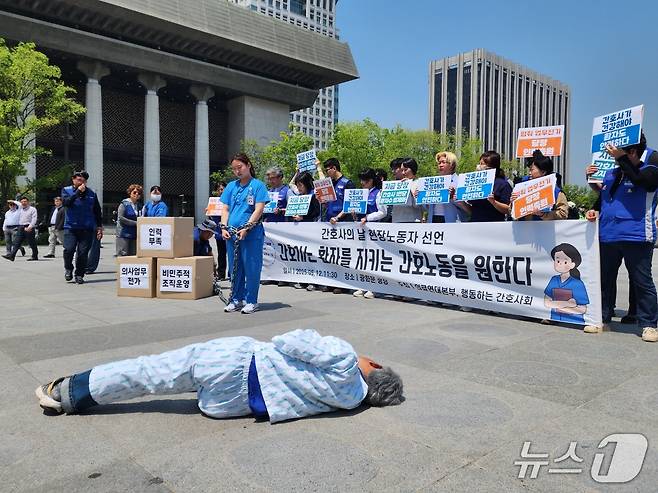 12일 서울시 종로구 광화문 광장에서 현직 간호사가 '인력 부족'과 '의사 업무 전가''비민주적 조직 운영' 등 현실적인 문제로 인해 환자를 돌볼 수 없음을 상징하는 퍼포먼스를 선보이고 있다. 2025.05.12/ⓒ 뉴스1 권진영 기자