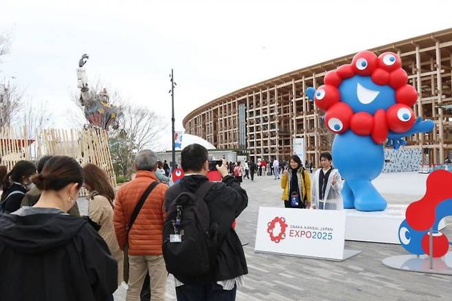 오사카·간사이 만국박람회(오사카 엑스포)가 개막한 13일 박람회장 내부에서 관람객들이 엑스포 캐릭터인 '먀쿠먀쿠'를 배경을 기념사진을 찍고 있다. 연합뉴스