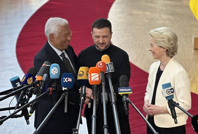 볼로디미르 젤렌스키 대통령(가운데)이 6일(현지시간) 벨기에 브뤼셀 EU 특별정상회의에 참석해 안토니우 코스타 EU 정상회의 상임의장(왼쪽), 우르줄라 폰데어라이엔 EU 집행위원장의 환영을 받고 있다. /연합뉴스