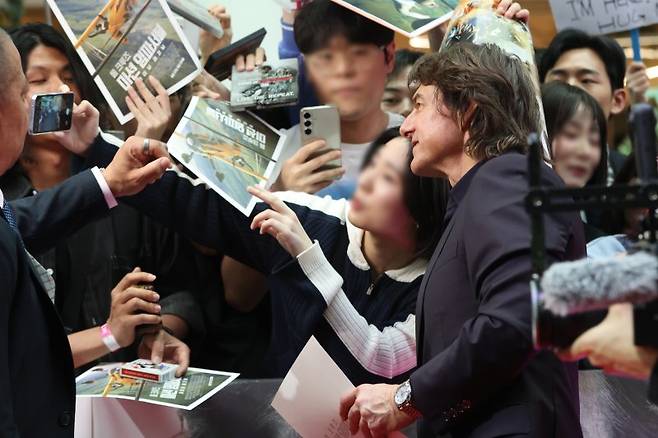 할리우드 배우 톰 크루즈가 지난 8일 서울 송파구 롯데월드 아이스링크에서 열린 영화 '미션 임파서블: 파이널 레코닝' 레드카펫 행사에서 팬서비스를 하고 있다. 연합뉴스