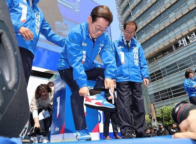 이재명 더불어민주당 대선 후보가 6·3 대선 공식 선거운동 첫날인 12일 서울 광화문 청계광장에서 열린 출정식에서 통합을 상징하는 선거 유세용 운동화를 신고 있다. 공동취재