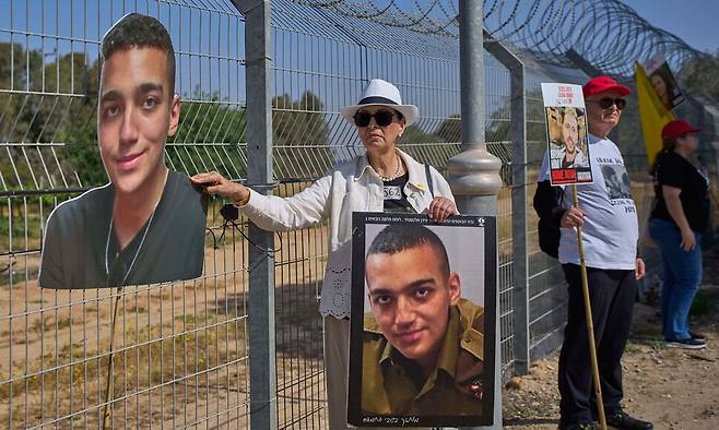 지난달 20일 이스라엘 남부 키부츠(집단 농장) 니르 오즈의 가자 국경 근처에서 에단 알렉산더(사진)의 조모가 손자의 사진을 들고 인질 송환을 촉구하고 있다. 니르오즈/AP 연합뉴스